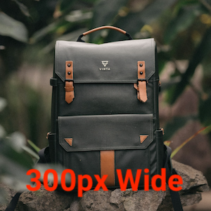 A dark gray backpack with brown leather accents and a top handle